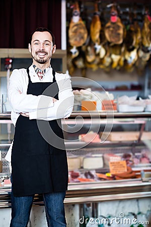 Positive male assistant working with meat Stock Photo